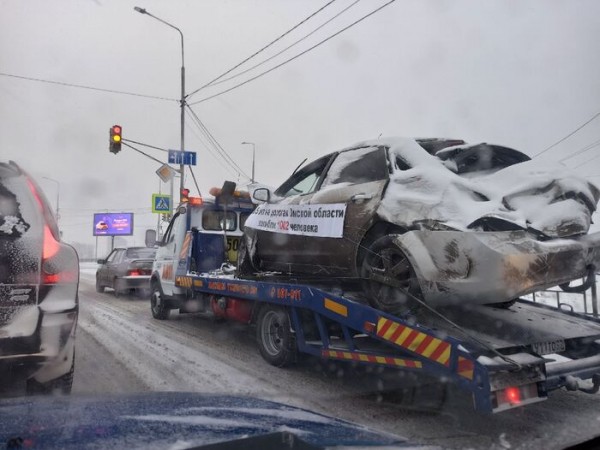 По улицам Омска эвакуаторы провезли разбитые машины с пугающим текстом на плакатах