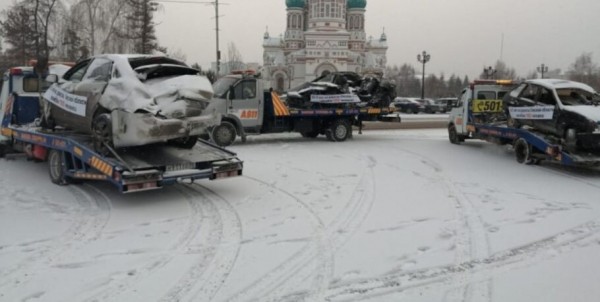 По улицам Омска эвакуаторы провезли разбитые машины с пугающим текстом на плакатах